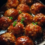 Slow-cooked Asian meatballs in a crockpot, garnished and ready to serve.
