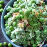 Delicious cold green pea salad with fresh vegetables and dressing