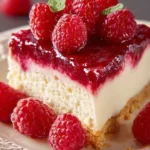 Slice of delicious raspberry cheesecake topped with fresh raspberries and whipped cream