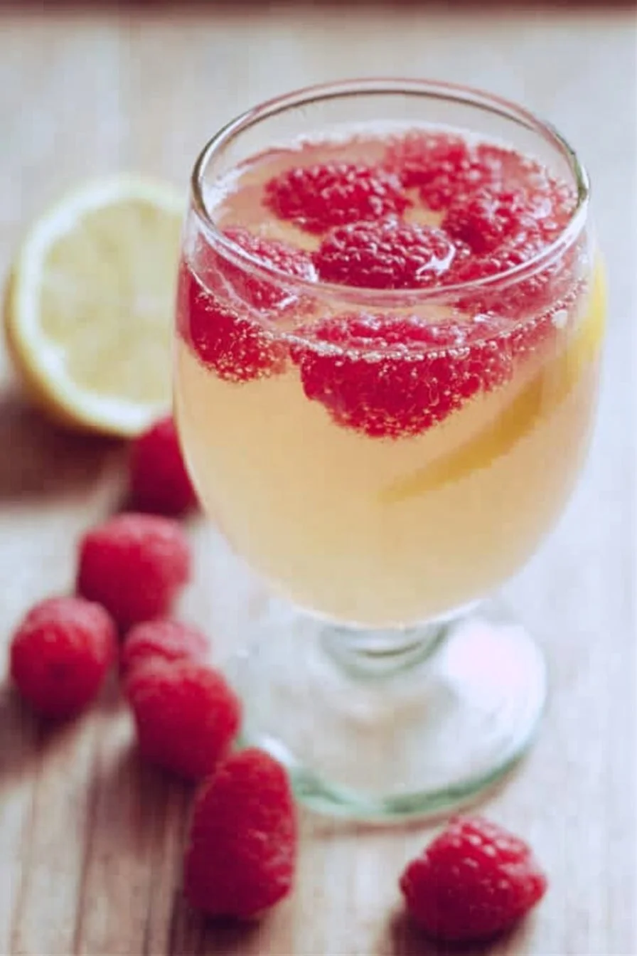 Raspberry Limoncello Prosecco cocktail garnished with fresh raspberries.